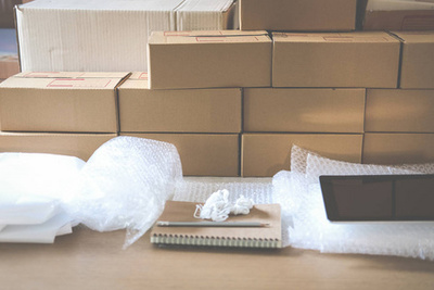 創業的小企業主在工作場所的紙板箱上寫地址。自由職業者企業家賣家準備包裹盒交付產品給客戶。網上銷售, 電子商務理念